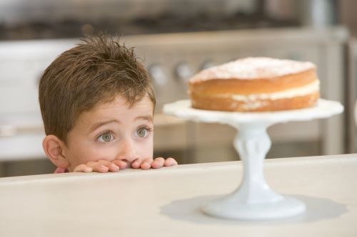 Boy staring longingly at cake at home