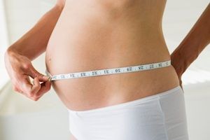 Pregnant woman measuring stomach